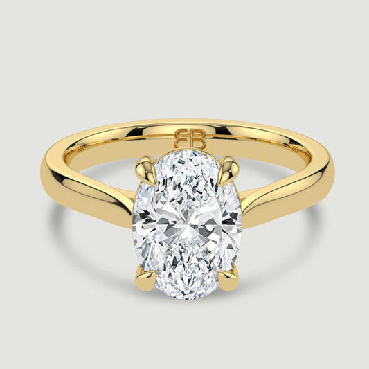 An 18ct yellow gold single stone diamond engagement ring, set with a lab-grown oval shape diamond held in a four claw setting. Viewed from above.