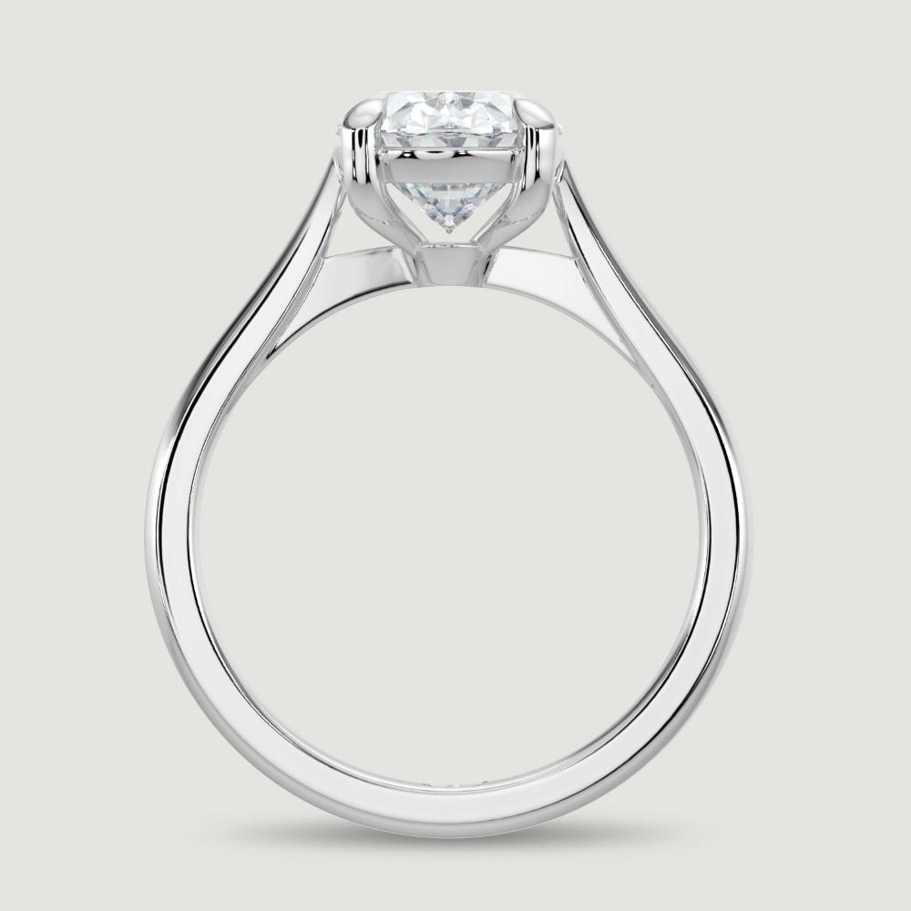 A platinum single stone diamond engagement ring, set with a lab-grown oval shape diamond held in a four claw setting. Viewed from the side.