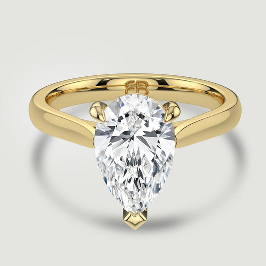 An 18ct yellow gold single stone diamond engagement ring, set with a lab-grown pear shape diamond held in a three claw setting. Viewed from above.