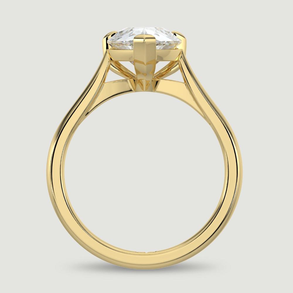 An 18ct yellow gold single stone diamond engagement ring, set with a lab-grown pear shape diamond held in a three claw setting. Viewed from the side.
