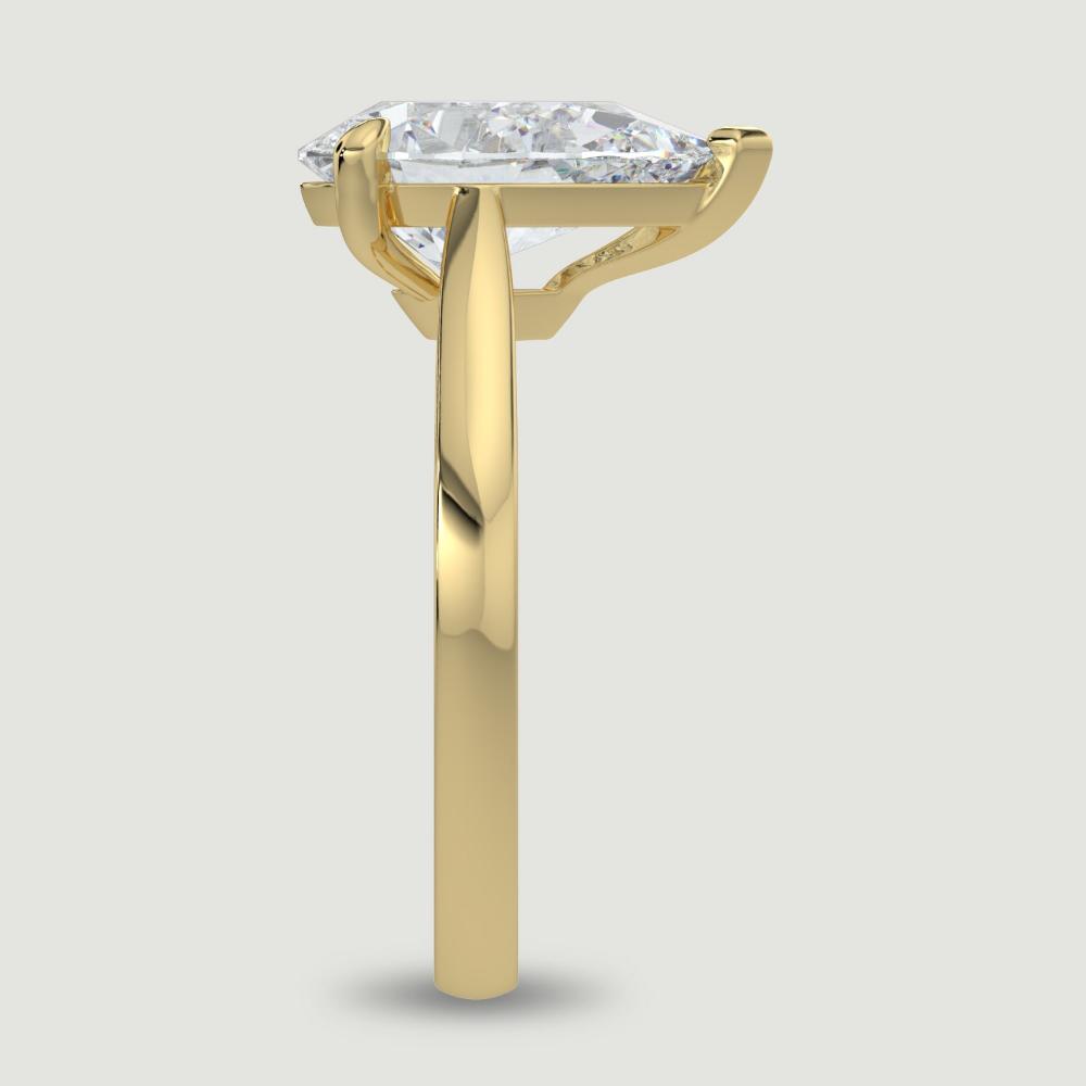 An 18ct yellow gold single stone diamond engagement ring, set with a lab-grown pear shape diamond held in a three claw setting. Viewed from the edge.