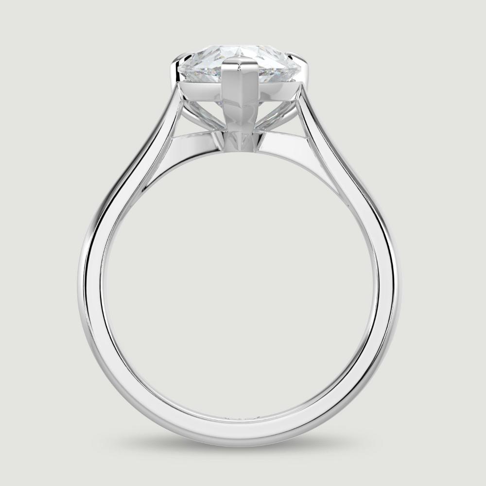 A platinum single stone diamond engagement ring, set with a lab-grown pear shape diamond held in a three claw setting. Viewed from the side.