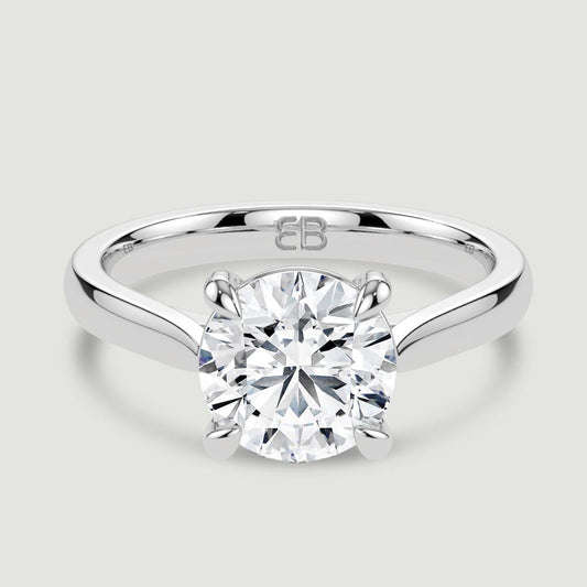A platinum single stone diamond engagement ring, set with a lab-grown round brilliant diamond held in a four claw setting. Viewed from above.