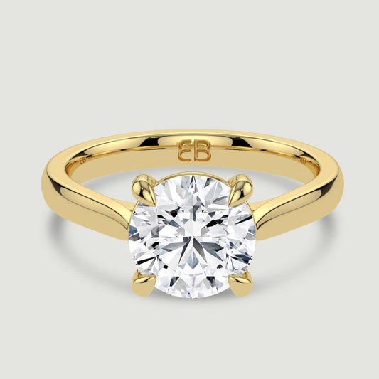 An 18ct yellow gold single stone diamond engagement ring, set with a lab-grown round brilliant diamond held in a four claw setting. Viewed from above.