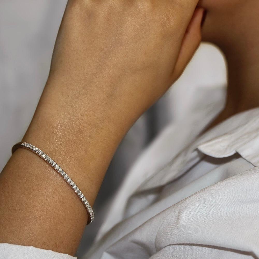 White gold lady’s bangle Micro-pavé set with round brilliant diamonds on the top half - photographed on model