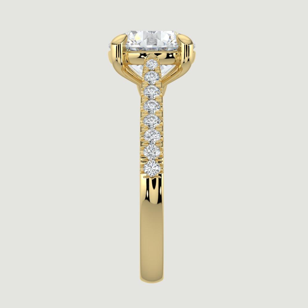 An 18ct yellow gold single stone diamond engagement ring, with micro-pavé set shoulders set with a lab-grown round brilliant diamond held in a four claw setting. Viewed from the edge.