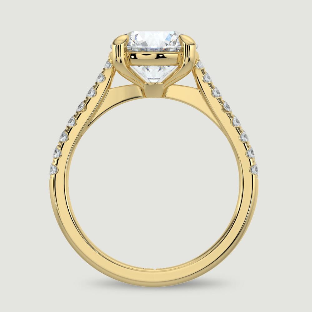 An 18ct yellow gold single stone diamond engagement ring, with micro-pavé set shoulders set with a lab-grown round brilliant diamond held in a four claw setting. Viewed from the side.