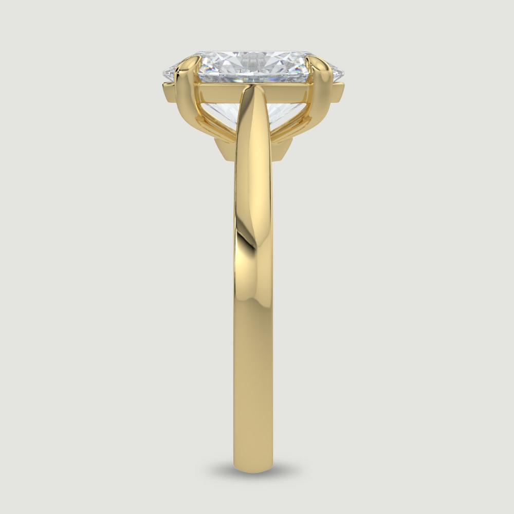 An 18ct yellow gold single stone diamond engagement ring, set with a lab-grown oval shape diamond held in a four claw setting. Viewed from the edge.