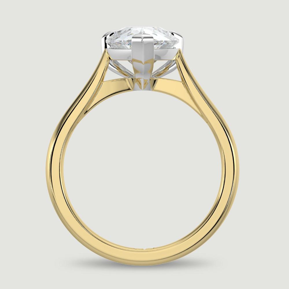 An 18ct yellow gold single stone diamond engagement ring, set with a lab-grown pear shape diamond held in a platinum three claw setting. Viewed from the side.