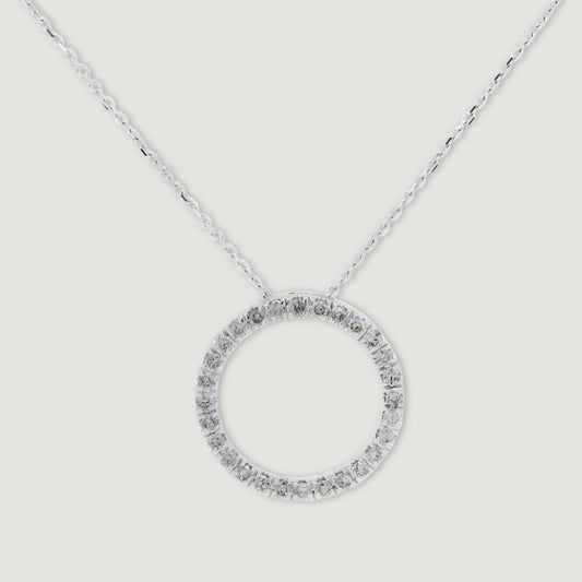 White gold diamond pendant, claw set with small round brilliant diamonds forming a circle 15mm in diameter, hanging on a fine chain - view from the front