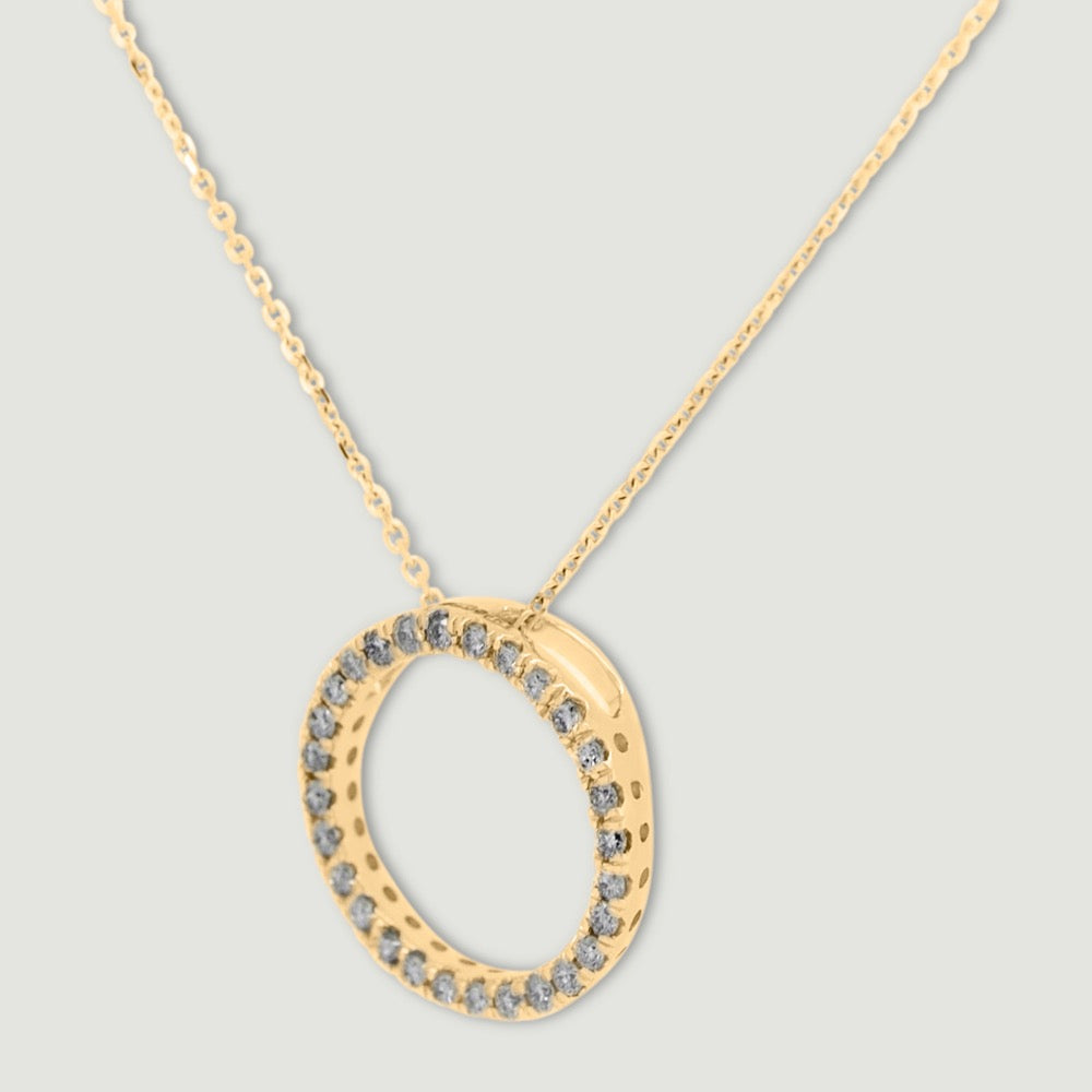 Yellow gold diamond pendant, claw set with small round brilliant diamonds forming a circle 15mm in diameter, hanging on a fine chain - view from an angle