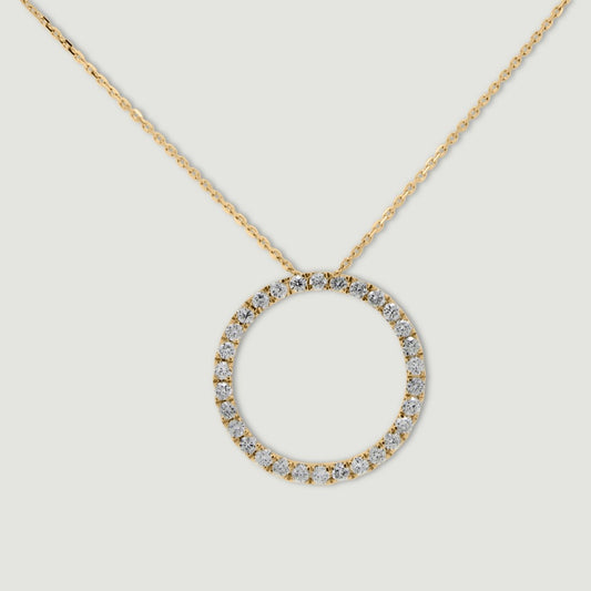 Yellow gold diamond pendant, claw set with small round brilliant diamonds forming a circle 18mm in diameter, hanging on a fine chain - view from front