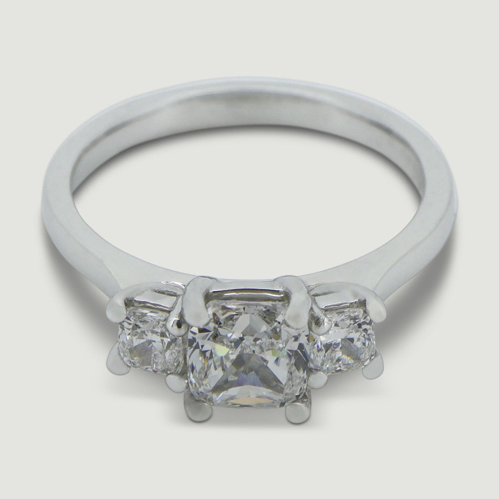 Platinum trilogy diamond engagement ring, claw set with three cushion shaped diamonds - view from  an angle