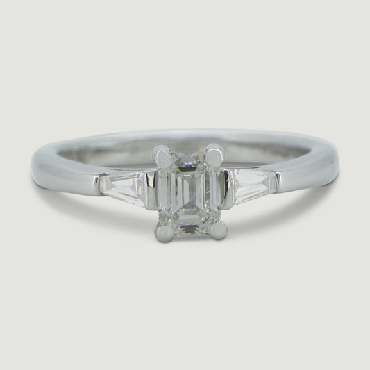 Platinum three stone ring set with an emerald cut centre stone and tapered baguette cut diamonds on the sides - view from the top