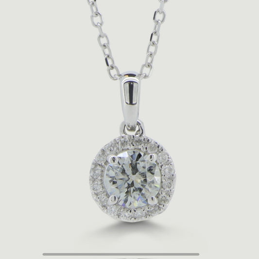 White gold diamond pendant set with a round central diamond with a micro-pavé set diamond halo surrounding hanging on a chain - view from the front