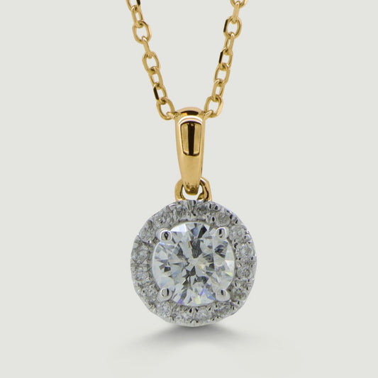 Yellow and white gold diamond pendant set with a round central diamond with a micro-pavé set diamond halo surrounding hanging on a chain - view from the front