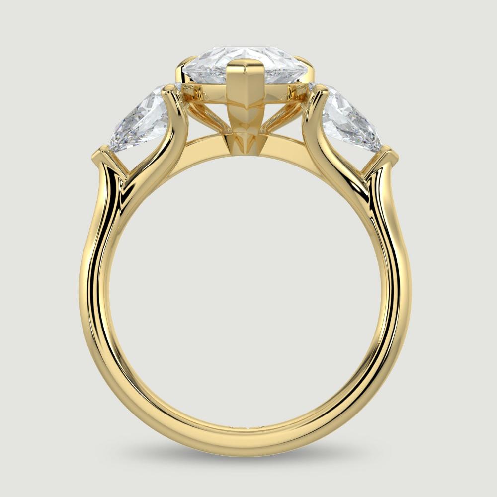 An 18ct yellow gold three stone diamond engagement ring, set with a lab-grown pear shape diamond centre stone held in a three claw setting flanked by a pear shaped lab-grown diamond on either side, held in three claws. Viewed from the side.