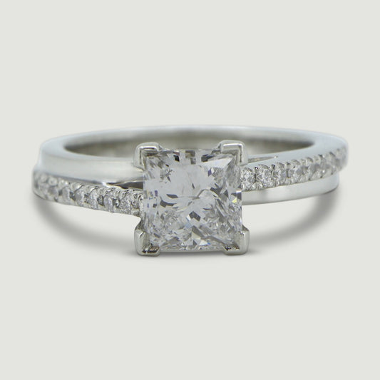 Platinum solitaire ring set with a princess cut centre stone and round diamonds micro-pavé set in the shoulders in an asymmetric style - view from the top