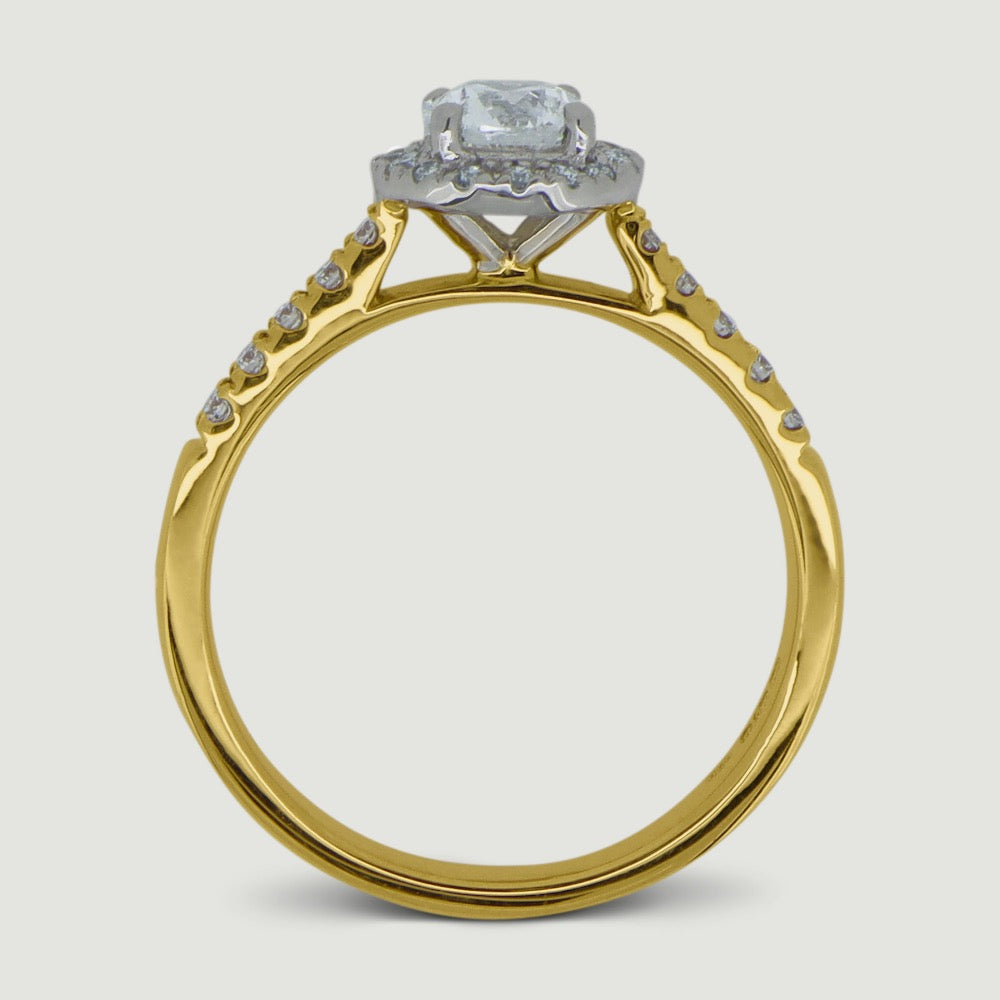 Gold and Platinum halo engagement Ring. The main Round diamond is held in a four claws and is surrounded by a mircro-pavé set halo of diamonds with diamonds micro-pavé set half way down the shoulders - view from the side