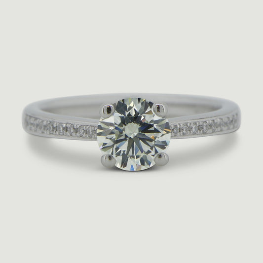 Platinum diamond engagement ring set with a round diamond in a four claw setting with grain set shoulder stones - view from the top