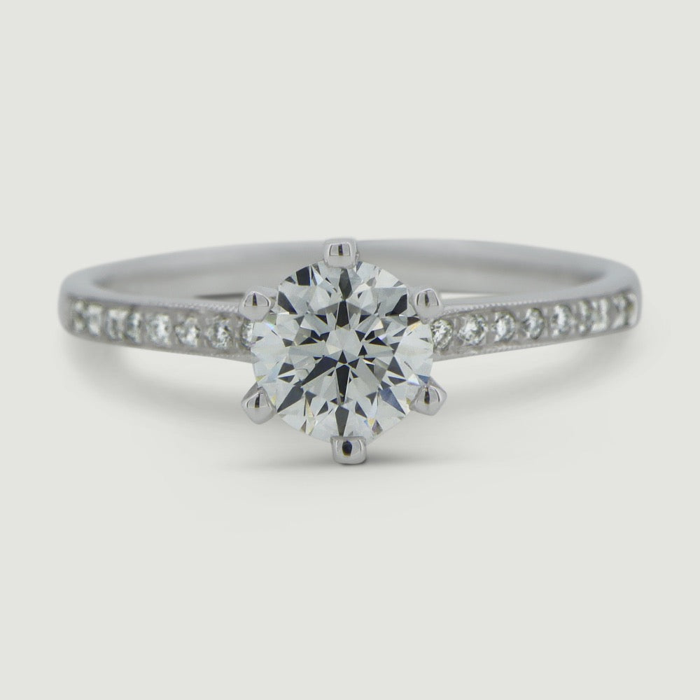 Platinum solitaire engagement Ring. The main Round diamond is held in a six claw Tiffany-style setting with diamonds grain set half way down the shoulders - view from the top