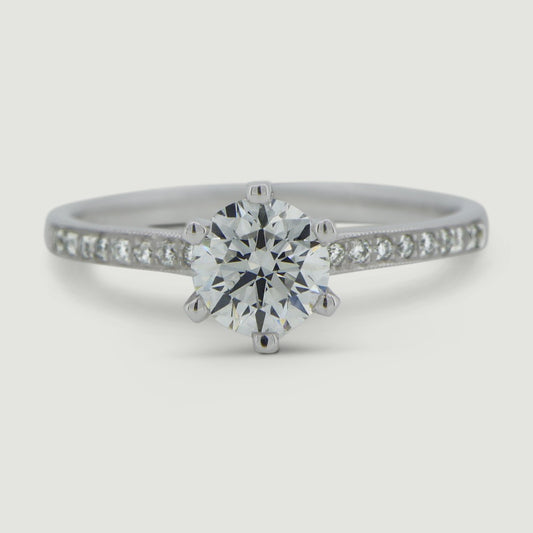 Platinum solitaire engagement Ring. The main Round diamond is held in a six claw Tiffany-style setting with diamonds grain set half way down the shoulders - view from the top