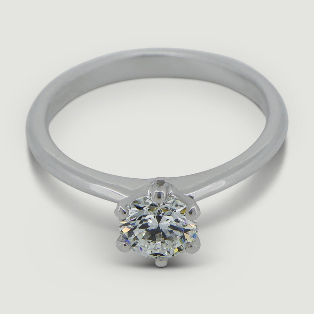 Solitaire six claw engagement ring in platinum, the ring has a delicate tapering band that draws focus onto the main diamond - view from an angle