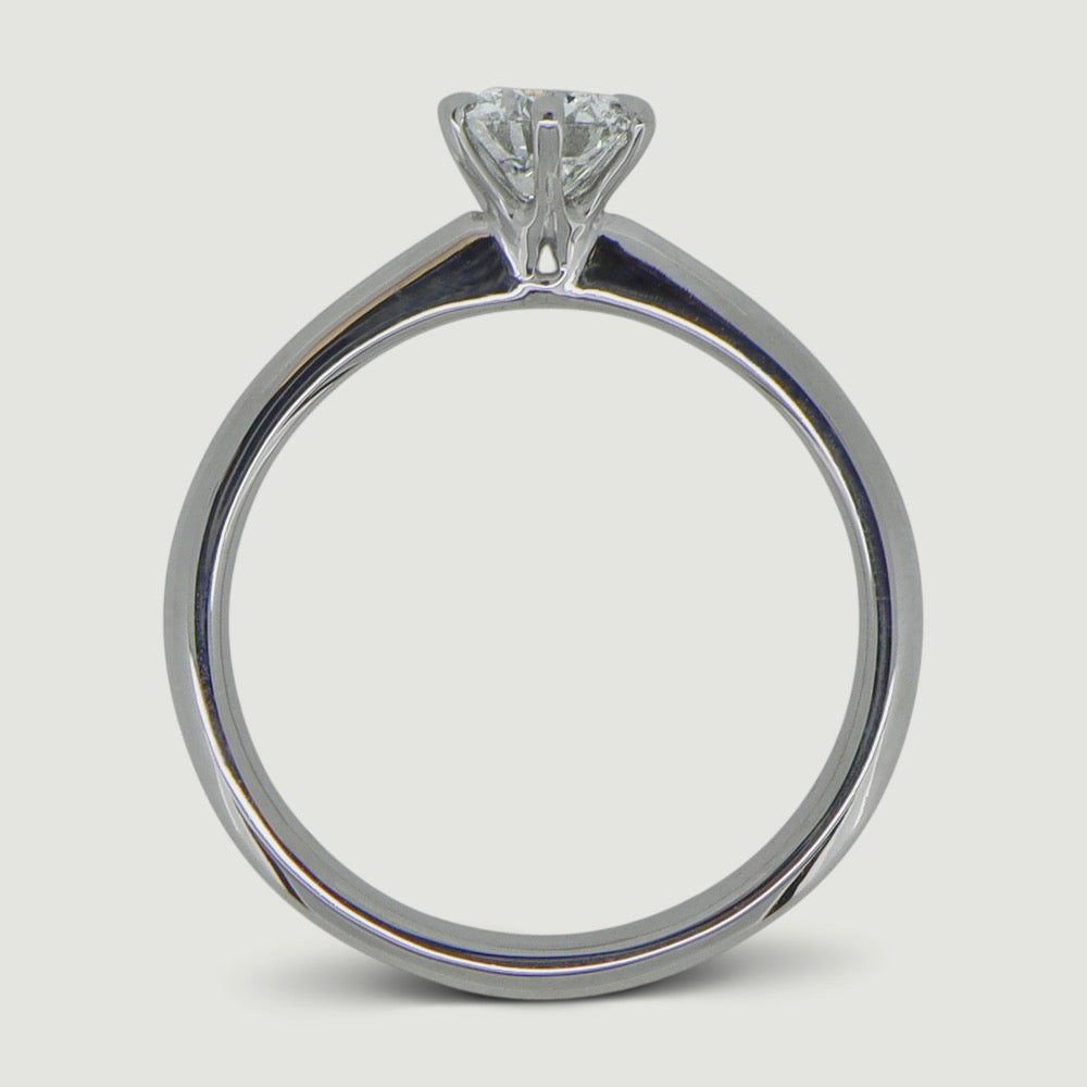 Solitaire six claw engagement ring in platinum, the ring has a delicate tapering band that draws focus onto the main diamond - view from the side