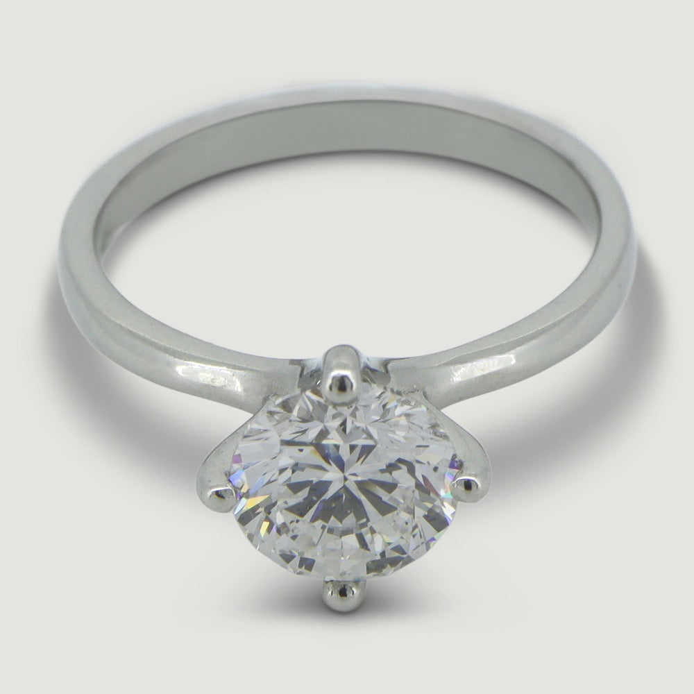 Platinum solitaire engagement Ring. The main Round diamond is held in a four claw compass setting- view from an angle